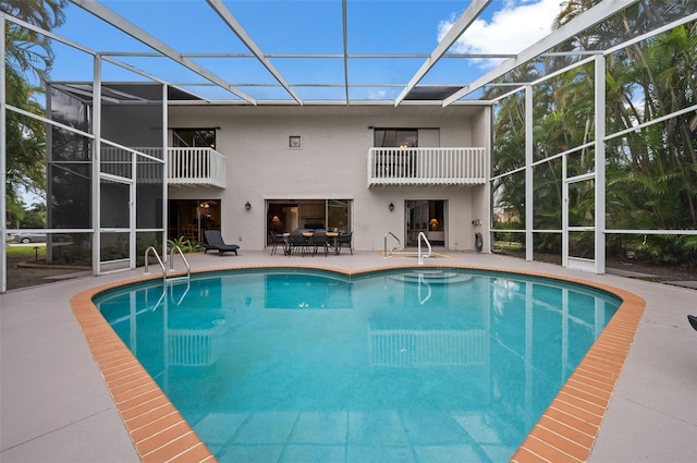 view of swimming pool with a patio and glass enclosure