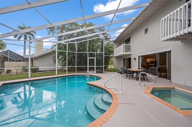 view of swimming pool with glass enclosure, a jacuzzi, and a patio area