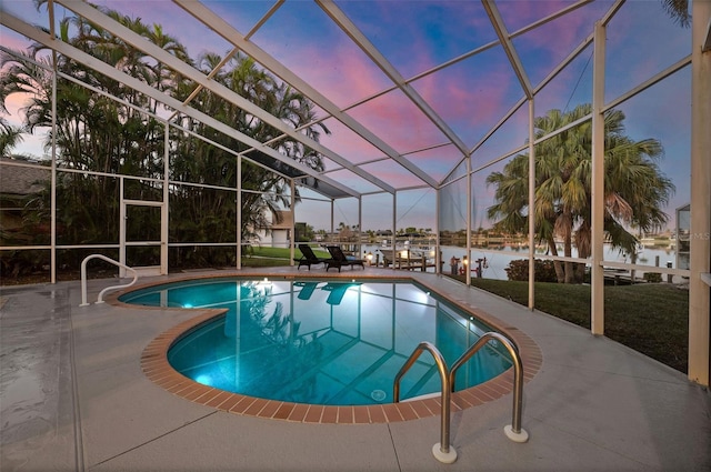 pool at dusk featuring a water view and a patio