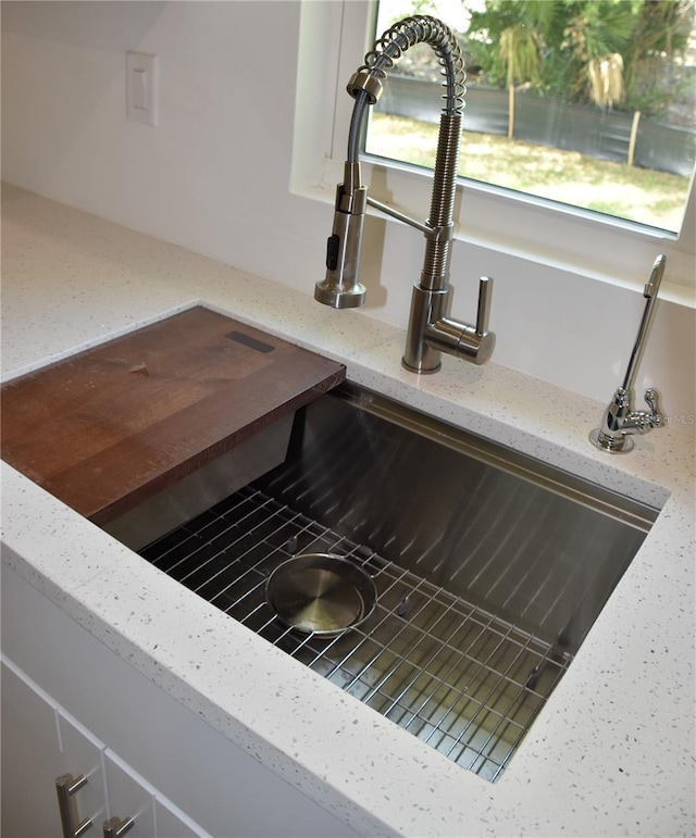 interior details with light stone countertops and sink