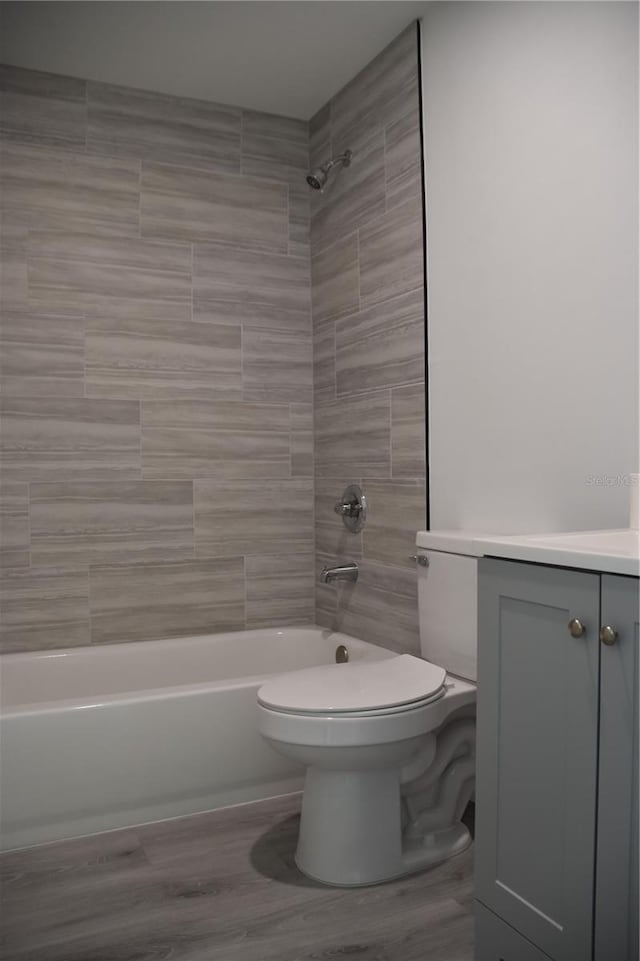 full bathroom featuring wood-type flooring, vanity, toilet, and tiled shower / bath