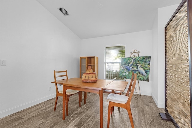 dining area featuring hardwood / wood-style floors and lofted ceiling