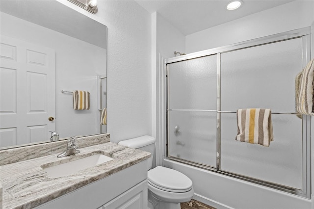 full bathroom featuring shower / bath combination with glass door, vanity, and toilet