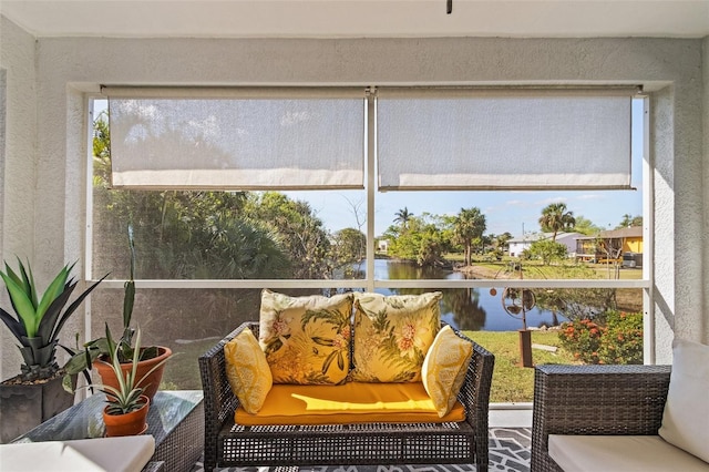 sunroom / solarium featuring a water view