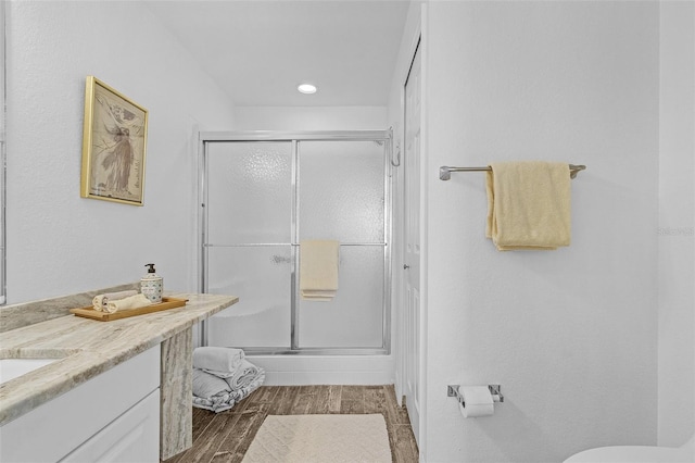 bathroom with vanity, hardwood / wood-style flooring, and walk in shower