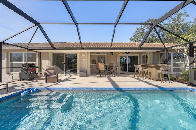 back of property with exterior bar, a lanai, ceiling fan, and a patio area