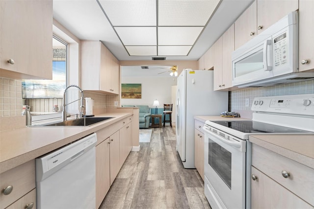 kitchen with white appliances, sink, decorative backsplash, ceiling fan, and light hardwood / wood-style floors