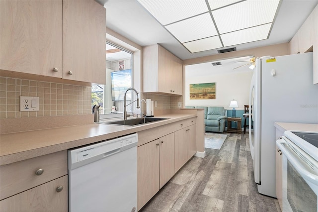 kitchen featuring light brown cabinets, white appliances, backsplash, sink, and light wood-type flooring