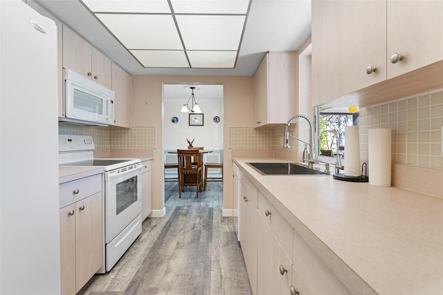 kitchen with decorative backsplash, white appliances, decorative light fixtures, and sink