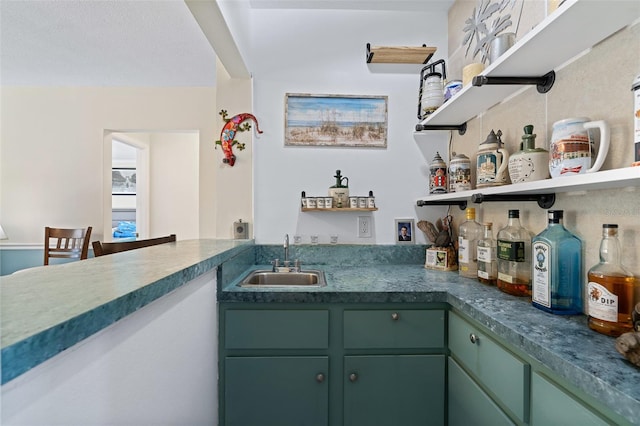 interior space with backsplash, green cabinetry, and sink