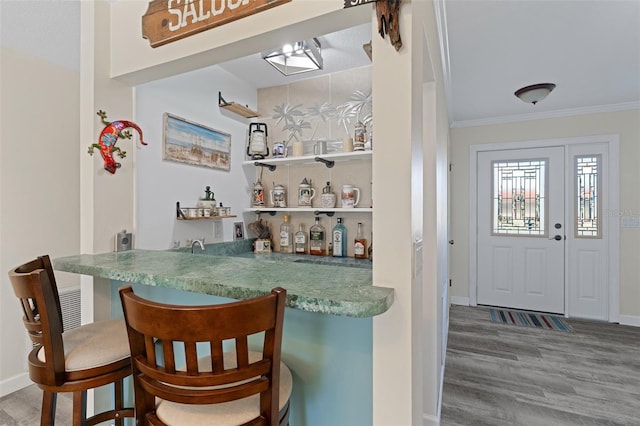 bar with hardwood / wood-style floors and ornamental molding