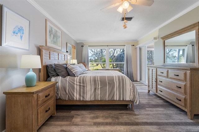 bedroom featuring ceiling fan, ornamental molding, dark wood-type flooring, and multiple windows