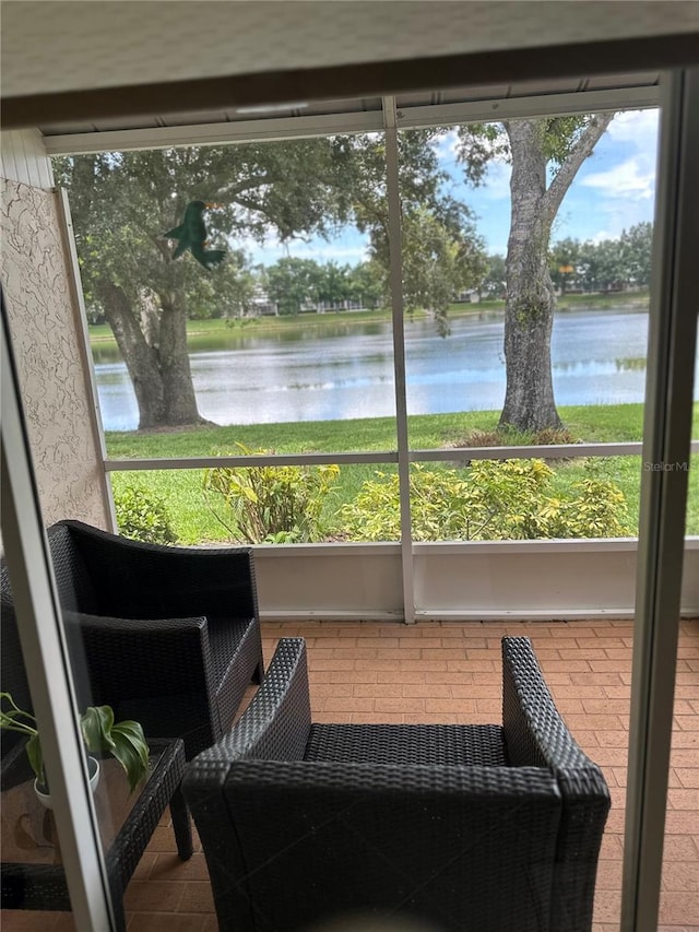 sunroom / solarium featuring a water view