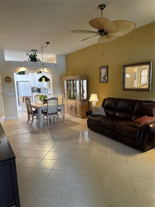 tiled living room with ceiling fan and lofted ceiling