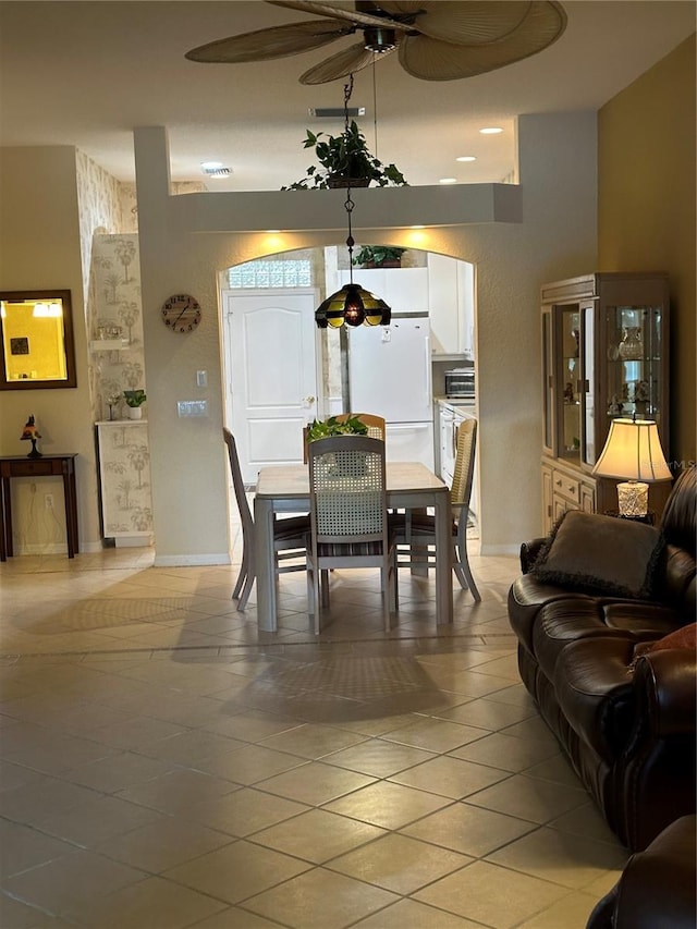 dining room with ceiling fan, baseboards, and light tile patterned floors