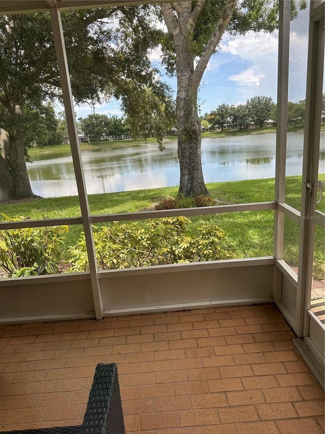 unfurnished sunroom featuring a water view