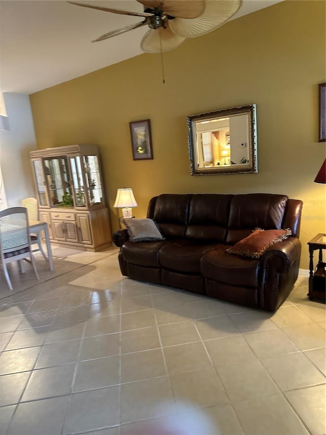 living area with a ceiling fan, vaulted ceiling, and light tile patterned floors