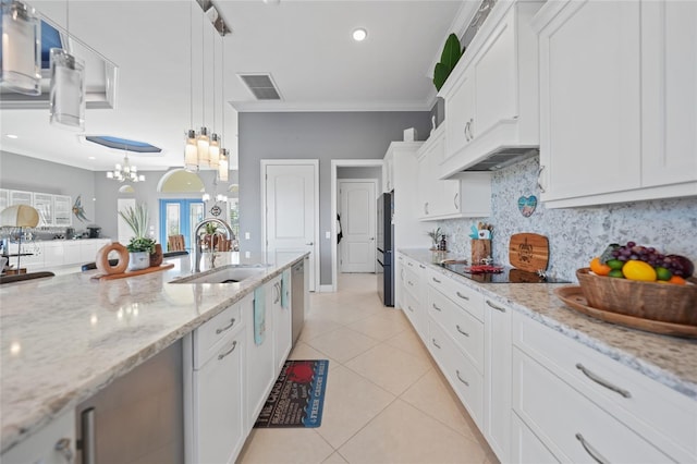 kitchen featuring white cabinets, an inviting chandelier, light stone countertops, and ornamental molding