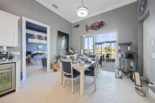 dining area featuring beverage cooler, ornamental molding, and light tile patterned flooring