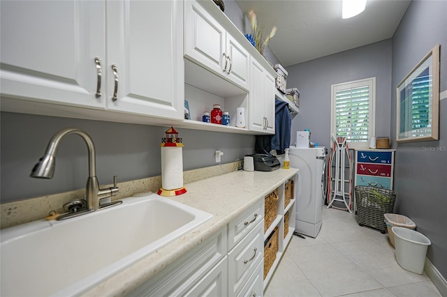 laundry room featuring washer and dryer, cabinets, light tile patterned floors, and sink