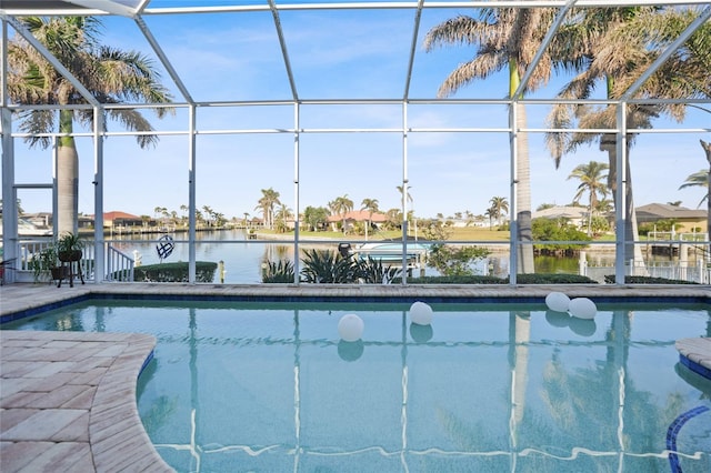 view of swimming pool with a water view and glass enclosure