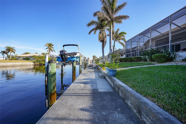 dock area featuring a lanai, a water view, and a yard