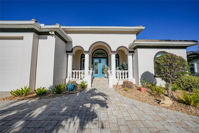 view of exterior entry with a porch and a garage