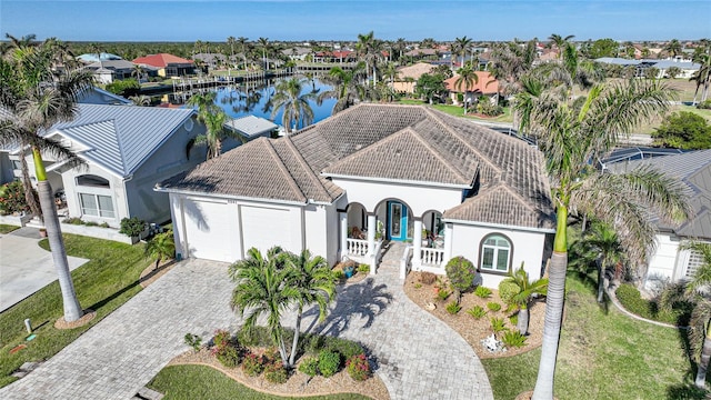 view of front of house with covered porch, a garage, and a water view