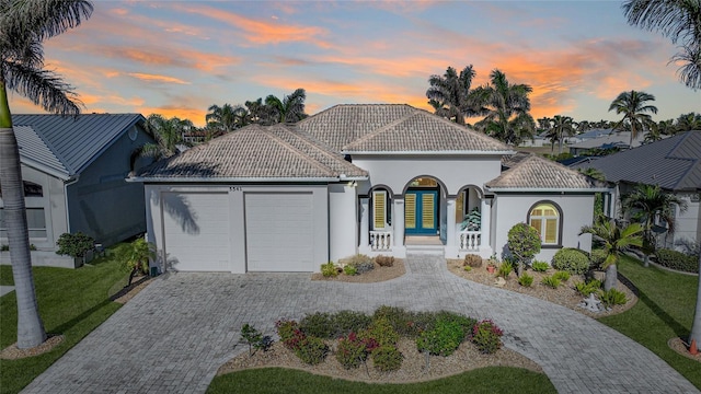 mediterranean / spanish-style house with a garage, a yard, and french doors