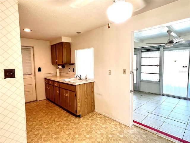 kitchen featuring ceiling fan, sink, and a textured ceiling