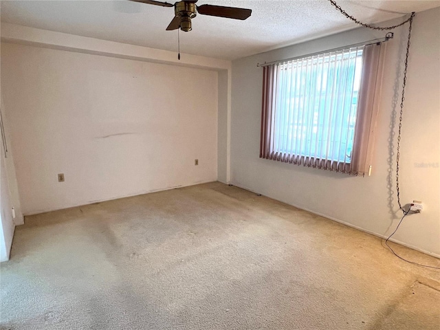 unfurnished room with ceiling fan, a textured ceiling, and carpet flooring