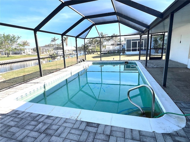 view of swimming pool featuring a patio area, glass enclosure, and a water view