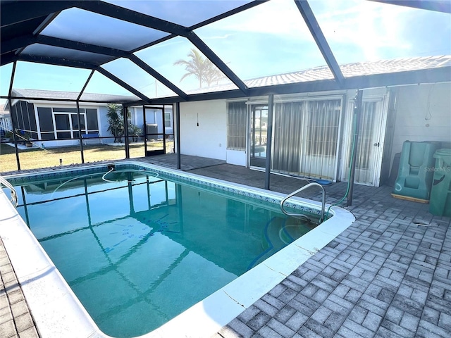 view of pool with glass enclosure and a patio area