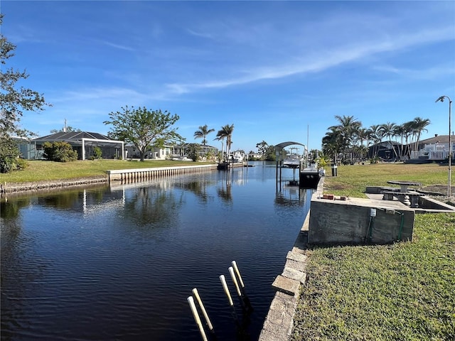 view of dock featuring a lawn and a water view