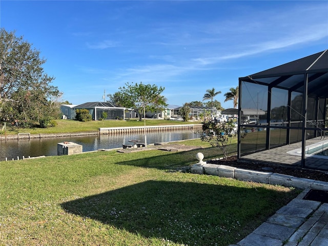 view of yard with a lanai and a water view