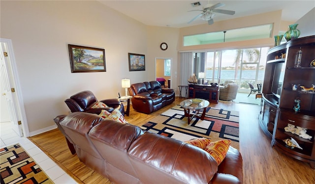 living room featuring ceiling fan, lofted ceiling, and light wood-type flooring