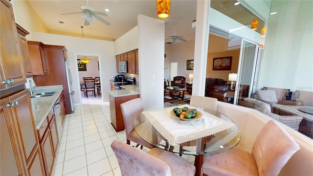 dining room with ceiling fan, light tile patterned flooring, and sink