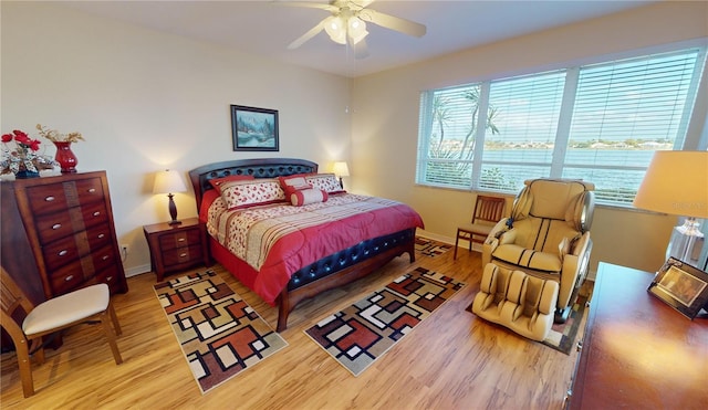 bedroom with light hardwood / wood-style floors and ceiling fan