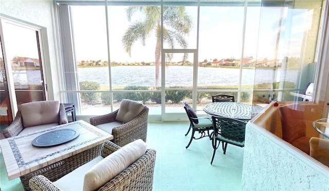 sunroom / solarium featuring a water view