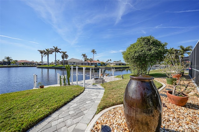 dock area featuring a lawn, glass enclosure, and a water view