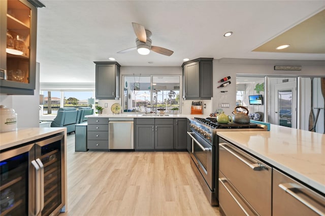 kitchen featuring sink, stainless steel appliances, wine cooler, light hardwood / wood-style flooring, and gray cabinets