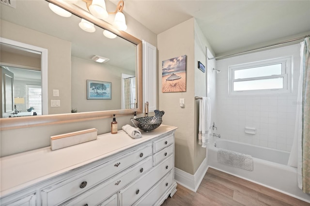 bathroom with hardwood / wood-style floors, vanity, and shower / bath combo with shower curtain