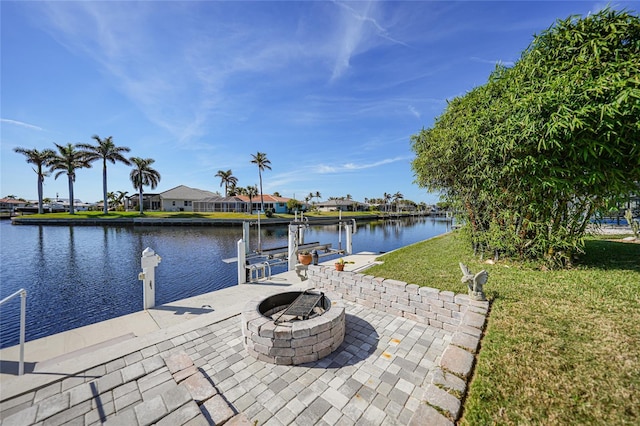 view of dock featuring a yard, a water view, and an outdoor fire pit