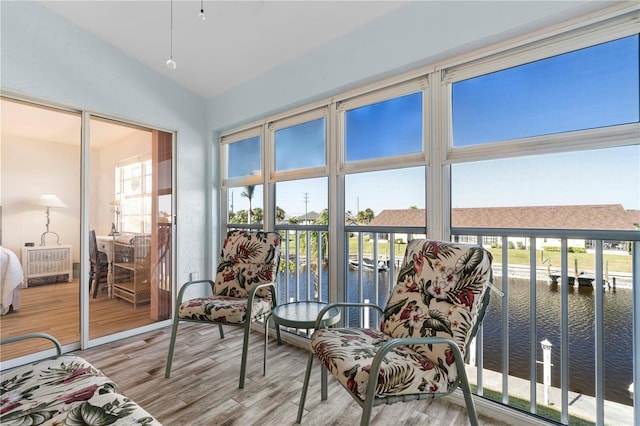 sunroom / solarium with a water view and lofted ceiling