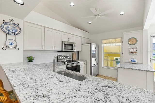 4000 Bal Harbor Blvd Unit 126, Punta Gorda, FL 33950 - kitchen with appliances with stainless steel finishes, a peninsula, light stone countertops, decorative backsplash, and a ceiling fan