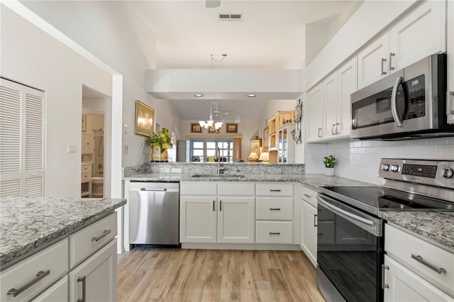 4000 Bal Harbor Blvd Unit 126, Punta Gorda, FL 33950 - kitchen featuring appliances with stainless steel finishes, a chandelier, tasteful backsplash, light wood-type flooring, and white cabinetry