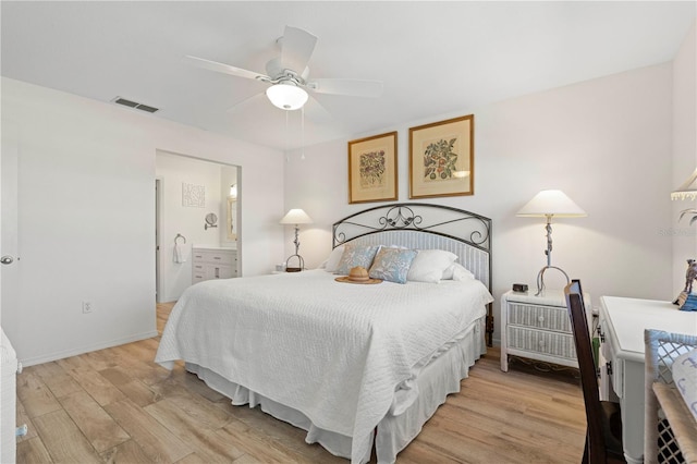 bedroom featuring ceiling fan, light wood-type flooring, and connected bathroom