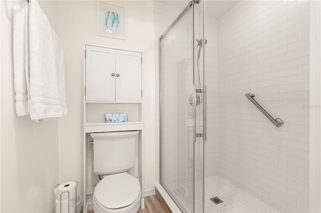 bathroom with hardwood / wood-style floors, toilet, and an enclosed shower