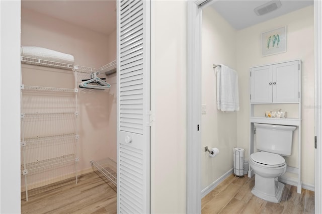 bathroom with hardwood / wood-style flooring and toilet