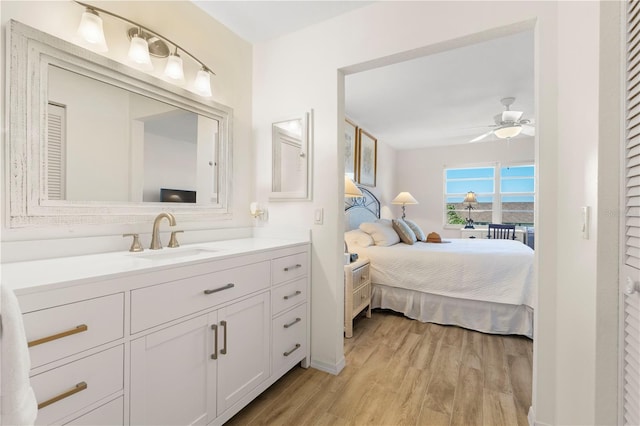 bedroom with light hardwood / wood-style floors, ceiling fan, and sink